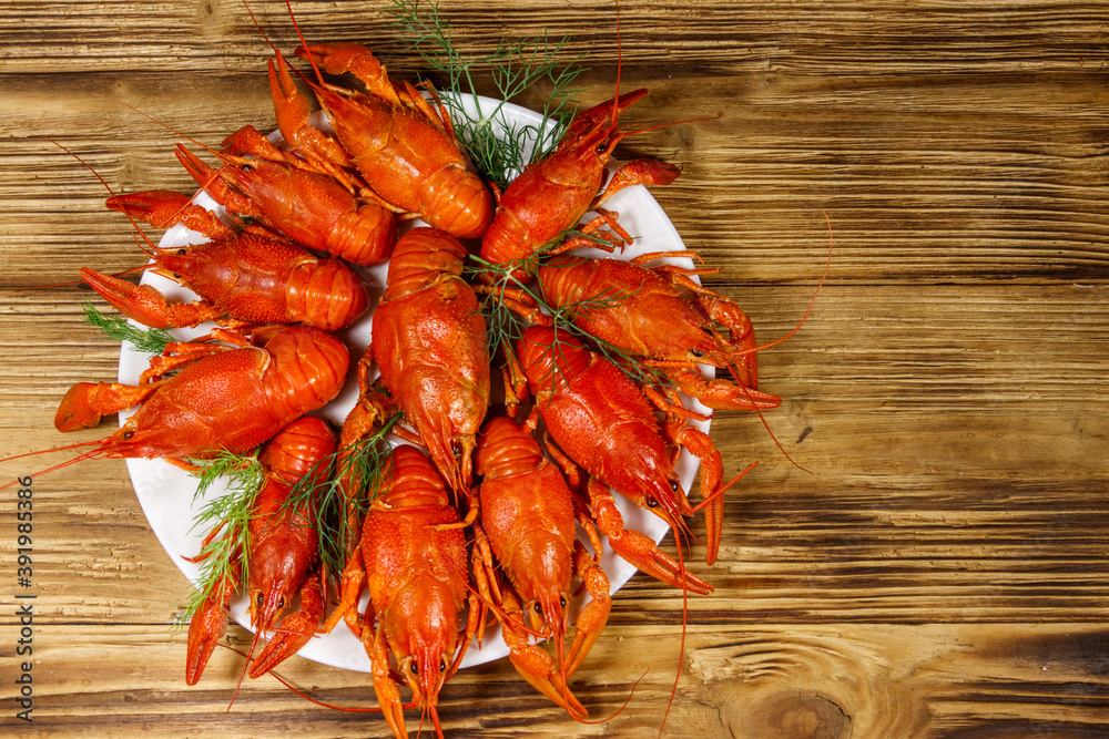 Boiled crayfish in plate on wooden table. Top view Boiled crayfish in plate on wooden table. Top view