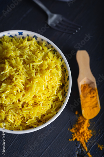 Bowl of yellow rice cooked from basmati rice with turmeric powder