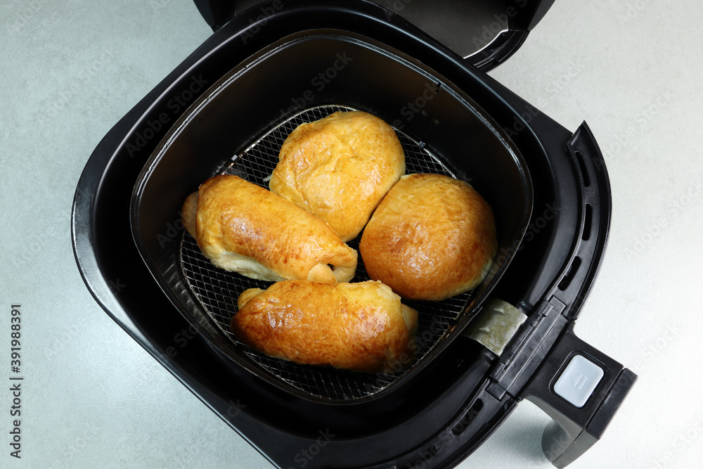 homemade ham cheese pies are baked in the black air fryer or oil free fryer for breakfast on the grey table in the kitchen during Christmas party with happy family