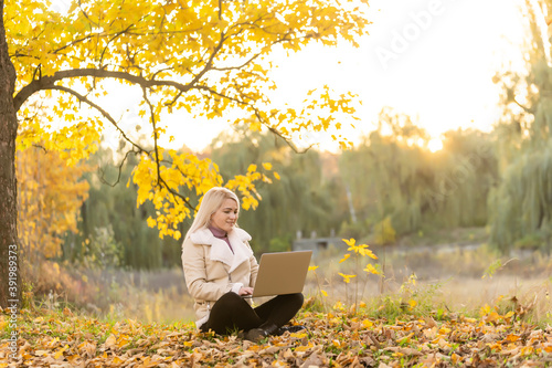 woman relaxes in park while working on her laptop