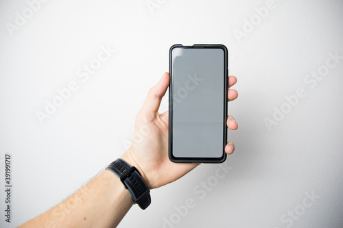 hand holding a smartphone with white screen on a white backgroundhand holding a smartphone with white screen on a white backgroundhand holding a smartphone with white screen on a white background photo