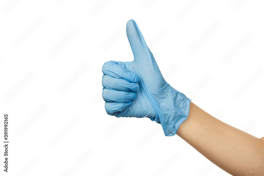 Female hand of a surgeon in a blue medical glove shows a thumbs up sign isolated on a white background Female hand of a surgeon in a blue medical glove shows a thumbs up sign isolated on a white background