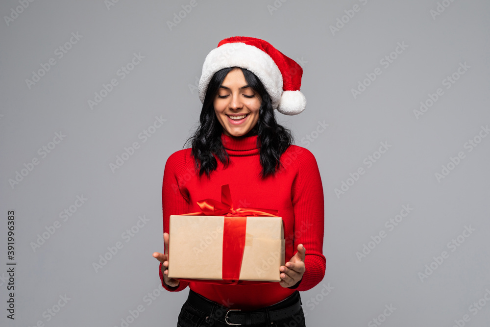 Christmas woman received a gift isolated on gray background. Santa hat isolated portrait of a woman on a gray background.