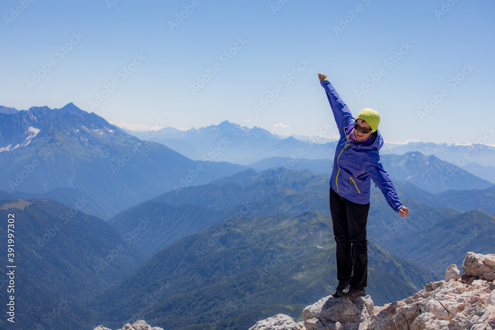 Fototapeta premium Young woman on a hike overlooking the high mountains