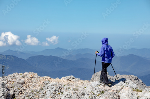 Young woman on a hike overlooking the high mountains