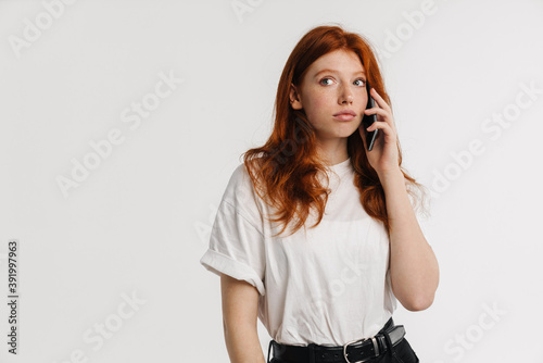 Ginger beautiful focused girl talking on cellphone