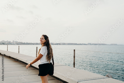 blonde woman walks along the bay with her computer bag