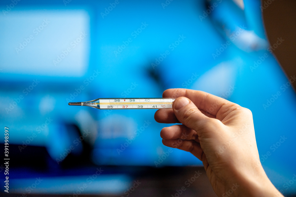 Woman Checking Body Temperature Using Mercury Thermometer At Modern