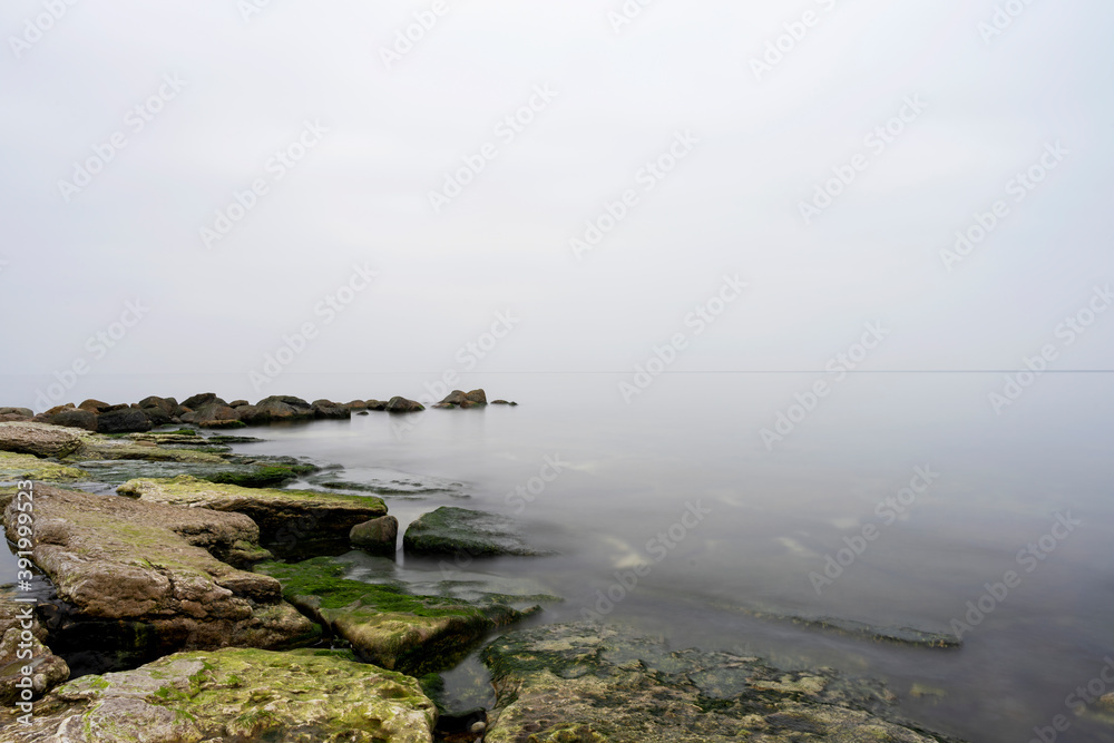 Fog rolling in from the ocean over coastal landscape on the island of Gotland in Sweden