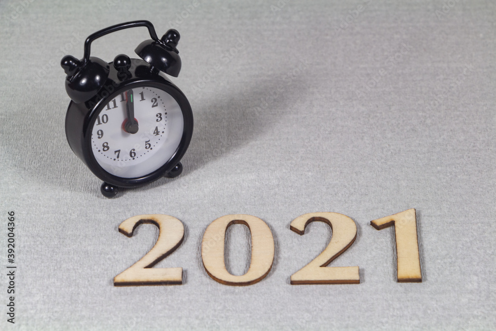 2021 and black alarm clock on gray background 2021 and black alarm clock on gray background