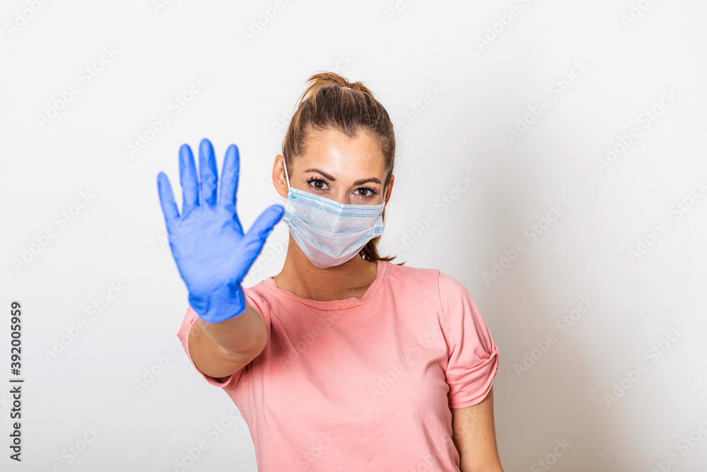 Portrait of young woman wearing face protective mask to prevent Coronavirus and anti-smog. Portrait of young woman wearing face mask showing stop sign with her hand. Covid-19 prevention concept Portrait of young woman wearing face protective mask to prevent Coronavirus and anti-smog. Portrait of young woman wearing face mask showing stop sign with her hand. Covid-19 prevention concept
