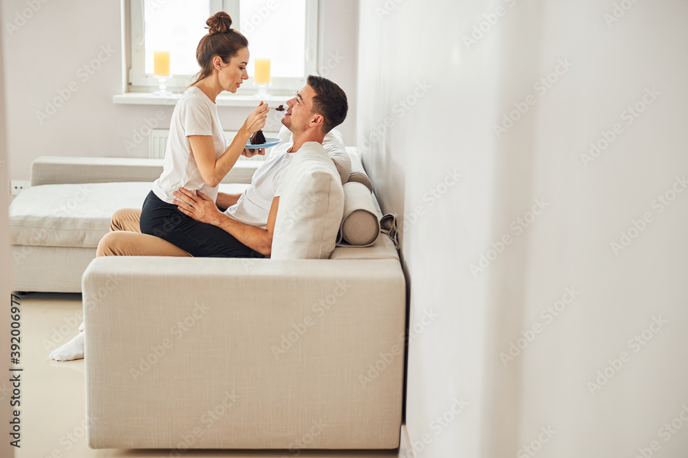 Caring girlfriend giving chocolate cake to her beloved man Caring girlfriend giving chocolate cake to her beloved man