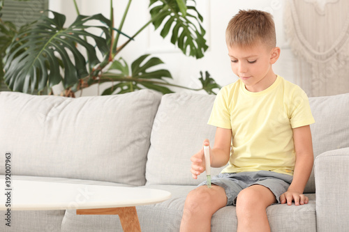 Little diabetic boy giving himself insulin injection at home