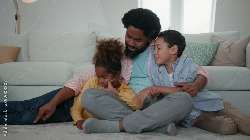 They innovated new entertainment. Afro father and children having fun at home and improvising drawing on carpet They innovated new entertainment. Afro father and children having fun at home and improvising drawing on carpet