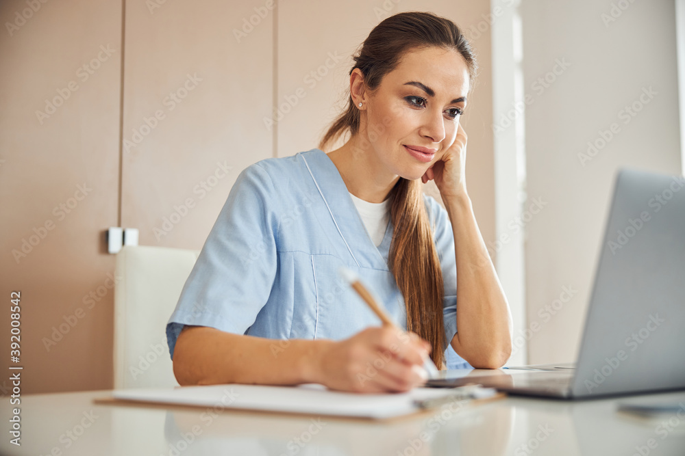 Beautiful female doctor working on her laptop Beautiful female doctor working on her laptop