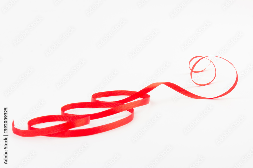 Top view of Red ribbon isolated shiny rolled on white background. Flat lay view. Top view of Red ribbon isolated shiny rolled on white background. Flat lay view.