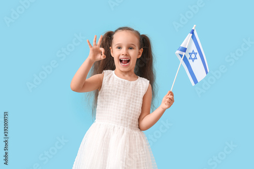 Little girl with the flag of Israel showing OK on color background