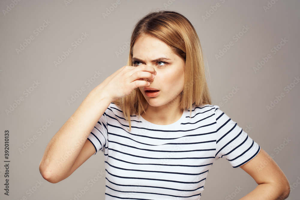 A woman with a displeased expression is gesturing with her hands T-shirt gray background A woman with a displeased expression is gesturing with her hands T-shirt gray background