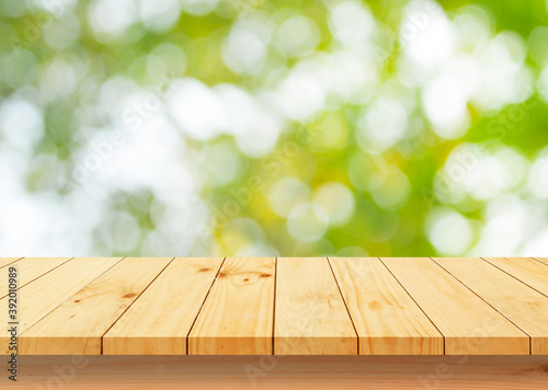 empty wooden table with green nature bokeh background