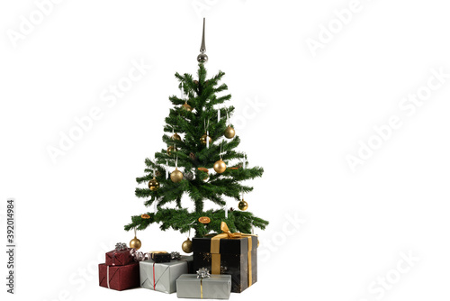 a decorated christmas tree with baubles and candles and gifts underneath