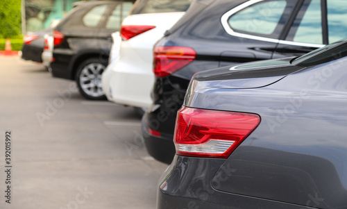 Closeup of rear side of grey car and other cars parking in parking area.