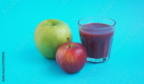 Healthy green and red apples raspberry fruit smoothie on bright blue background