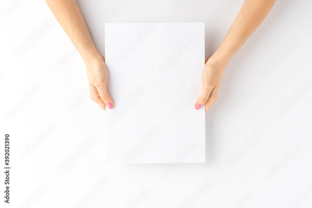 Woman’s hands holding empty white paper sheet. Close up