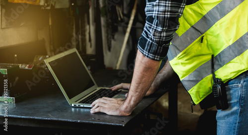 An engineer uses a laptop to works in the factory.