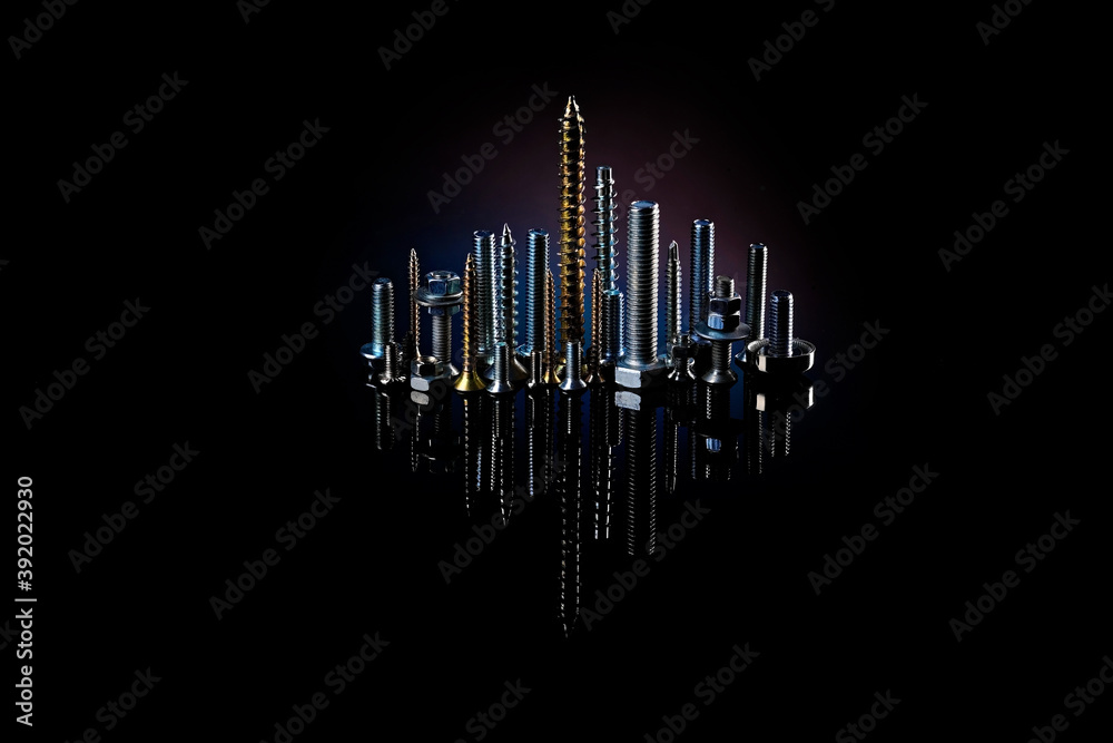 Night city of screws, bolts and nuts with reflection on a black background. The idea of advertising photos of fasteners Night city of screws, bolts and nuts with reflection on a black background. The idea of advertising photos of fasteners