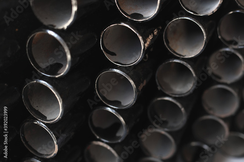 Black metal pipes for gasification or water supply. Industrial background close up