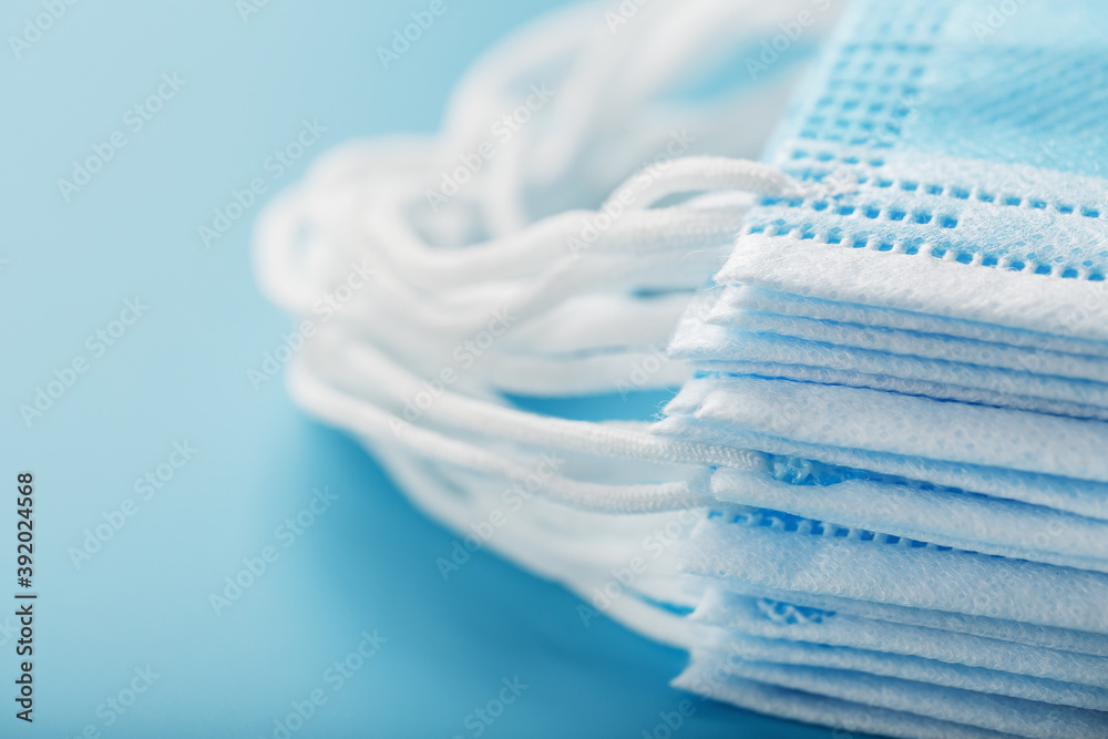 Stack of protective medical masks on a blue background, isolate. Stack of protective medical masks on a blue background, isolate.