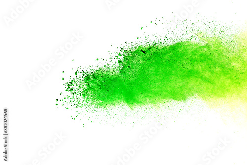 Freeze motion of green color powder exploding on white background.