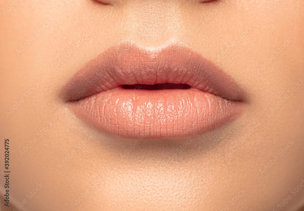 Fototapeta premium Lips. Close up portrait of beautiful young woman on studio background. Concept of cosmetics, makeup, natural and eco treatment, skin care. Shiny and healthy look, fashion, healthcare. Details.
