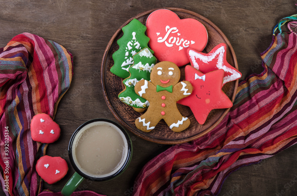 Christmas gingerbread cookies and a mug of cocoa and a scarf on a wooden top.