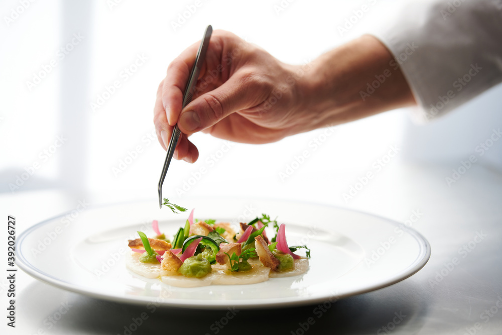 Chef Preparing Dish In Kitchen. Decorating Dish, Closeup Chef Preparing Dish In Kitchen. Decorating Dish, Closeup