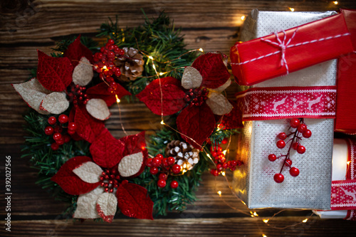 Presents and christmas crown on wooden background with lights. New year a Christmas concept.