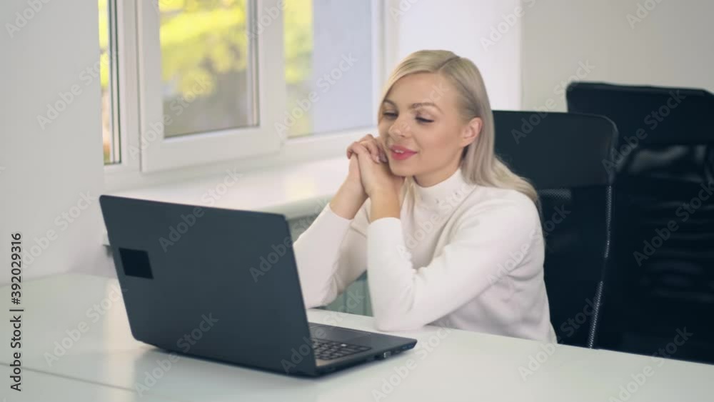 Smiling caucasian young business woman on video conference calling on laptop computer listen group by webcam in online chat or distance online teaching concept Smiling caucasian young business woman on video conference calling on laptop computer listen group by webcam in online chat or distance online teaching concept