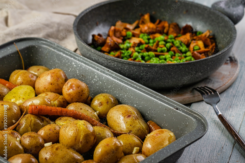 Fried potatoes and chanterelles in a pan. Edible mushrooms and baked vegetables. Healthy and tasty vegetarian organic food. Close-up