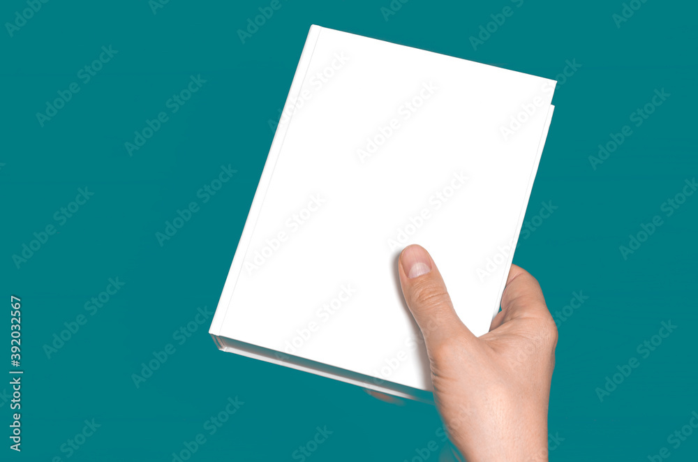 A mock-up of a white closed book with a place for text in a hand A mock-up of a white closed book with a place for text in a hand
