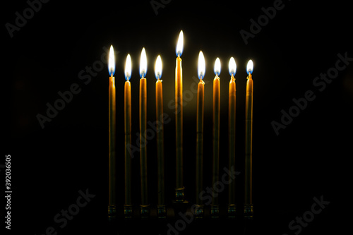 Lit Golden Hanukah Candles in Dark Room photo