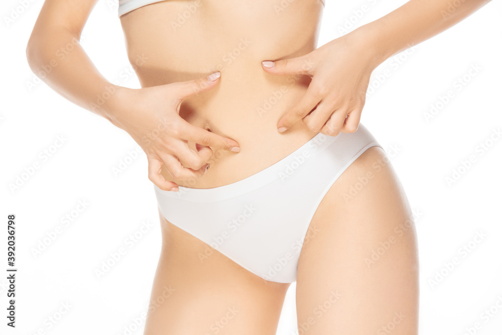 Belly skin. Close up beautiful female model on white background. Beauty, cosmetics, spa, depilation, diet and treatment, fitness concept. Fit and sportive, sensual body with well-kept skin.