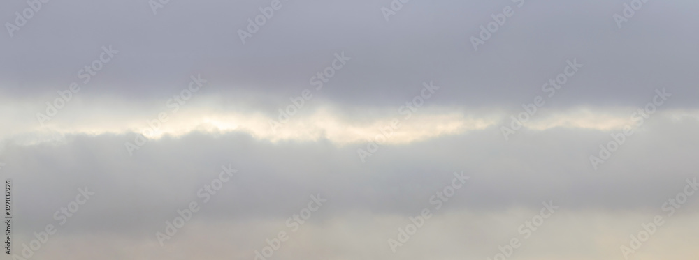 Overcast sky with gray clouds and light stripe in the middle, light blur, sky panorama Overcast sky with gray clouds and light stripe in the middle, light blur, sky panorama