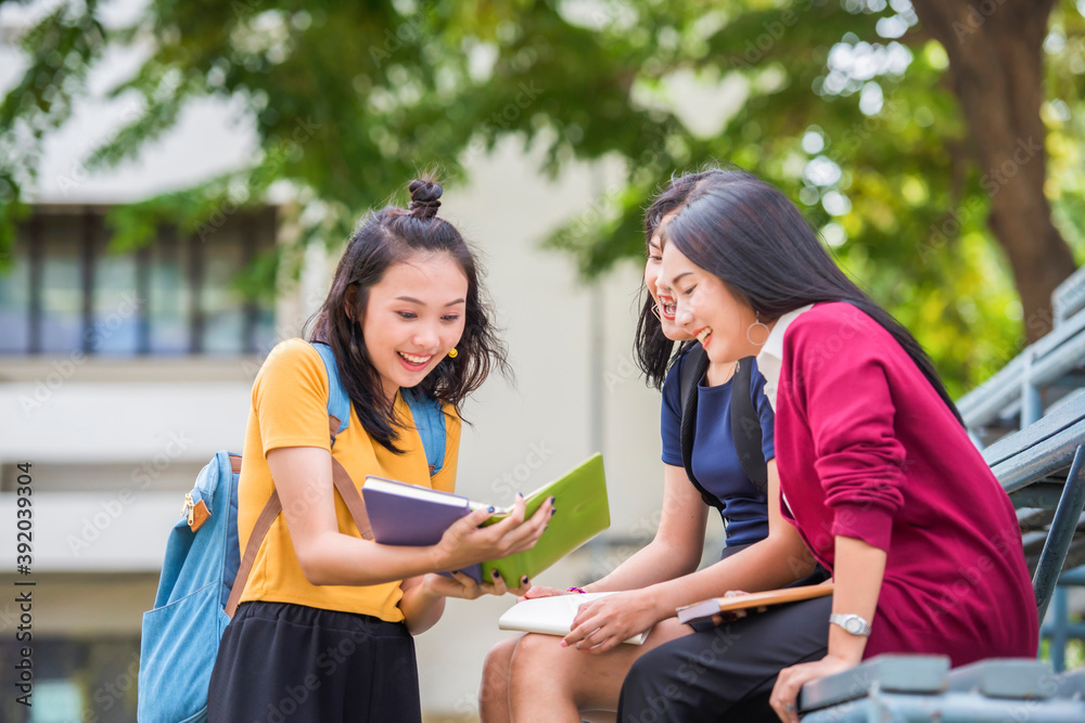 Young Asian students together group teenager reading book at high school university campus college knowledge center for study learning in outdoor. Young Asian students together group teenager reading book at high school university campus college knowledge center for study learning in outdoor.