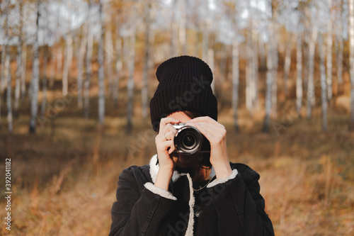 Portrait of a young woman with camera taking a picture in beauti photo