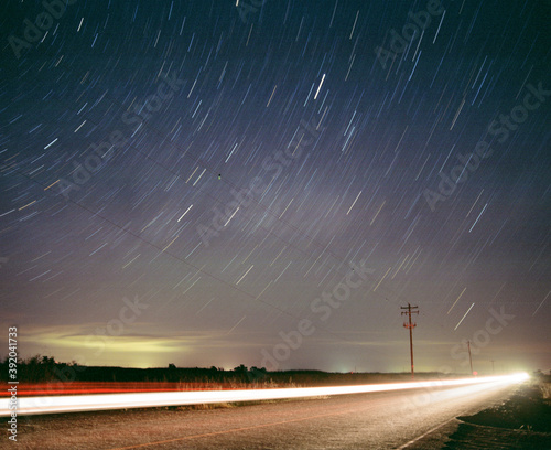 Star Trails above road with long exposure car and telephone pole photo