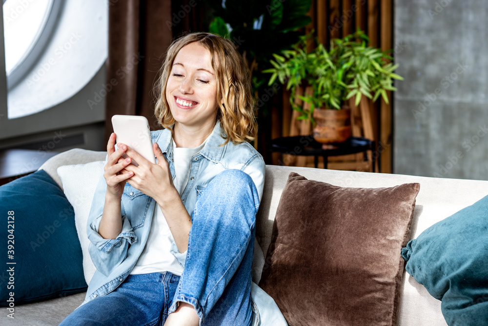 Young blond woman is using phone for online meeting with friends Young blond woman is using phone for online meeting with friends