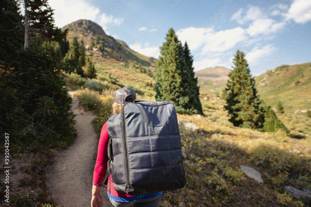 Rear view of woman hiking on mountain during summer Rear view of woman hiking on mountain during summer