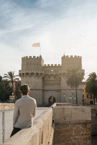 Valencia's Torres de Serrano at sunset with a young man photo