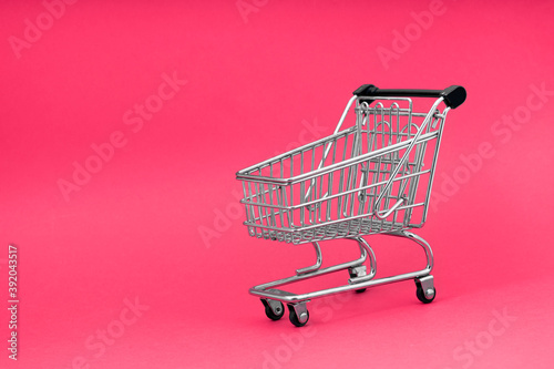 Black cart store trolley over pink background, design for black friday