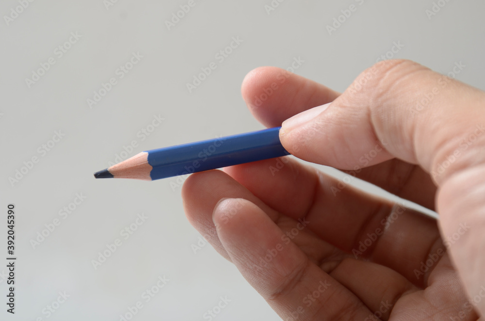 hand with blue color pencil hand with blue color pencil
